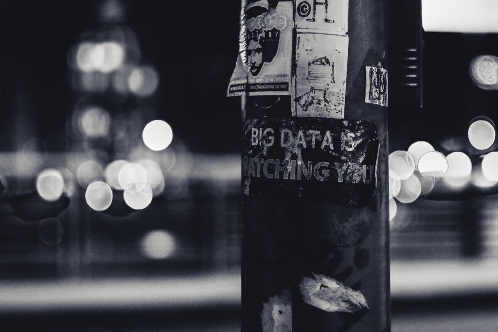 History of data privacy black and white photograph of telegraph pole with sign saying big data is watching you