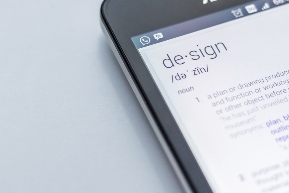 Cropped image of an iphone with the definition of design on the screen, denoting privacy by design