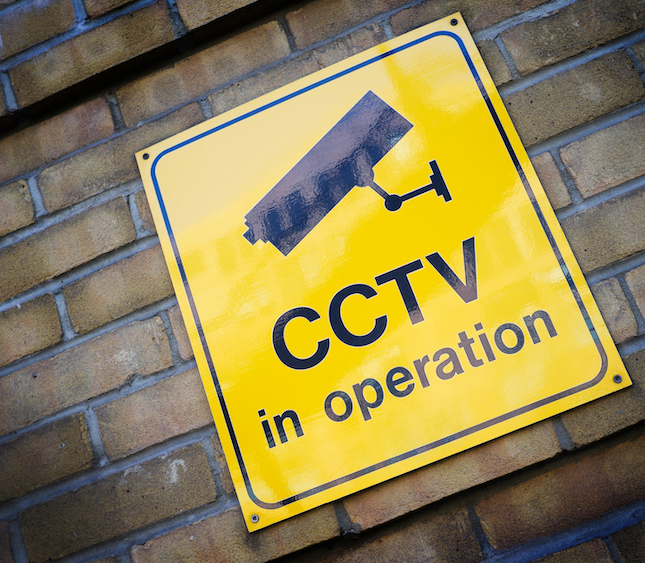 Brick wall with a CCTV in operation sign posted on it